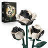 Three black-and-white cow-print rose building models with green stems, displayed beside their black SupreOwls product box on white.