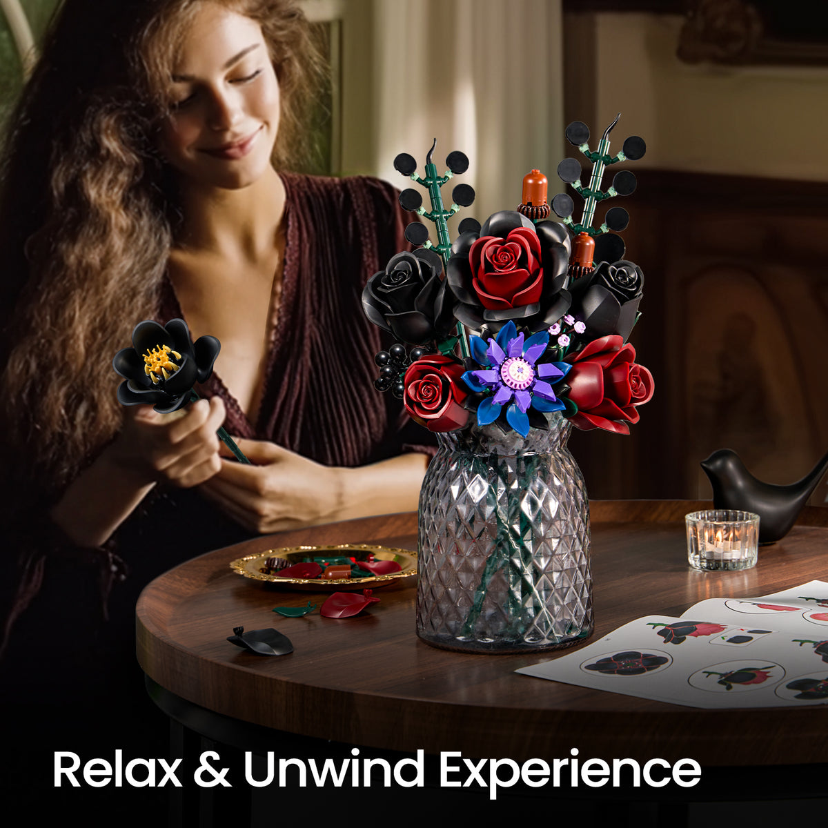 Woman assembling a gothic flower bouquet building set at a table, showing the creative DIY process with colorful flower pieces and a completed arrangement nearby.