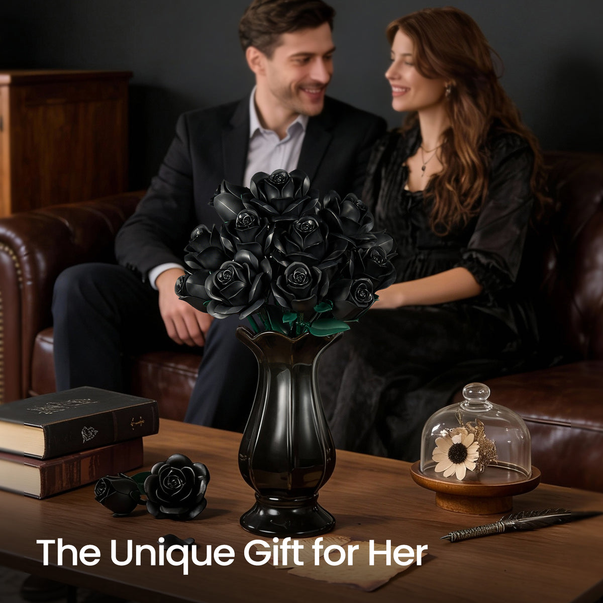 A black rose building block bouquet arranged in a vase on a wooden table, displayed in an elegant living room setting with a couple and dark romantic decor in the background.