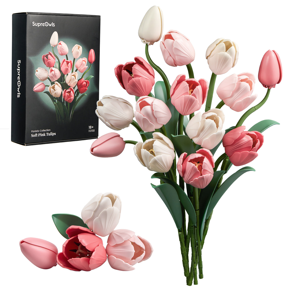 Standing pink-and-ivory tulip building bouquet with exposed stems on white, accompanied by its product box and several loose blossoms arranged at the lower left.