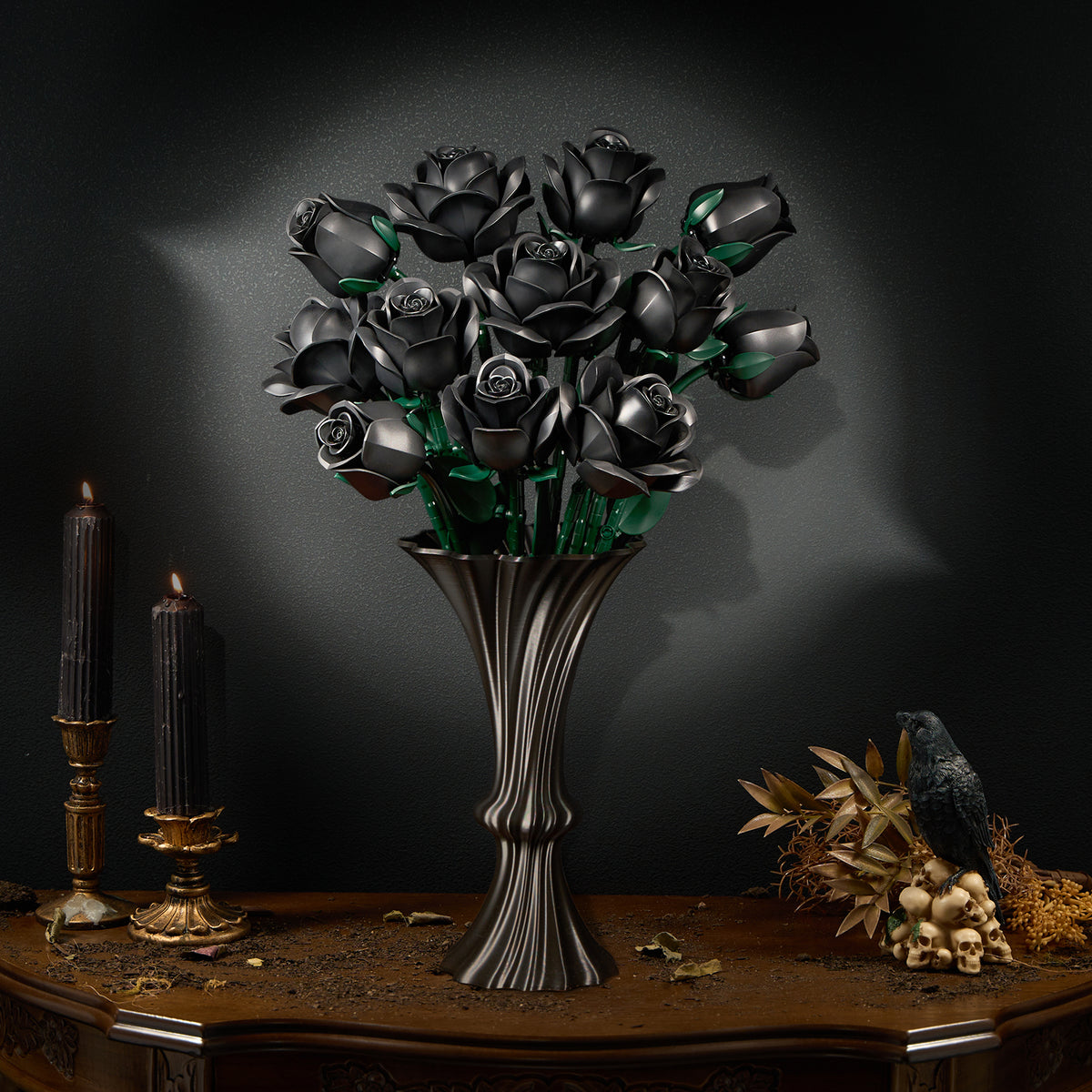 A bouquet of black roses arranged in a tall metallic vase, displayed on a wooden table with candles and dark decorative elements, creating a dramatic gothic floral decor scene.