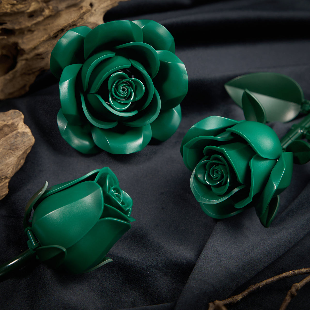 Close-up view of green roses building blocks featuring detailed layered petals, realistic rose shapes, and floral pieces arranged on a dark fabric background.