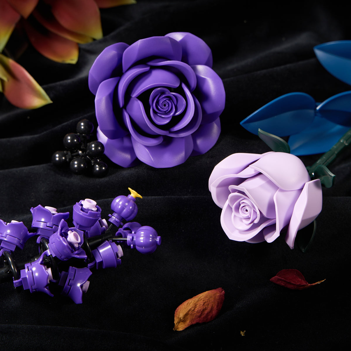 Close-up view of purple rose building blocks featuring layered petals, realistic floral details, and colorful botanical elements arranged on a dark background.