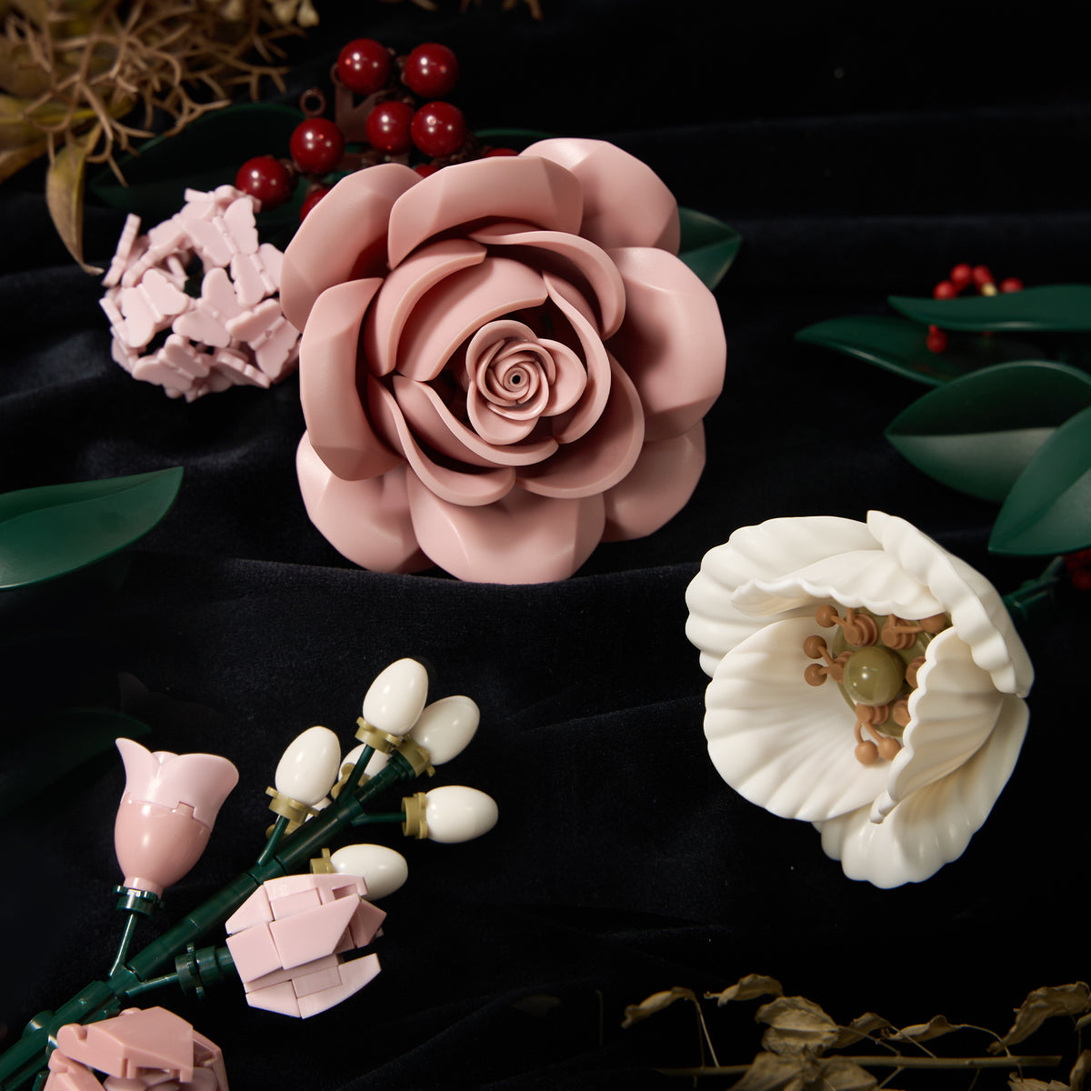 Close-up view of pink rose building blocks featuring realistic layered petals, delicate white flowers, and detailed floral elements arranged on a dark fabric background.