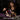 Woman assembling a Gothic Skull Floral Bouquet building set with purple and red flowers at a table in a dark interior