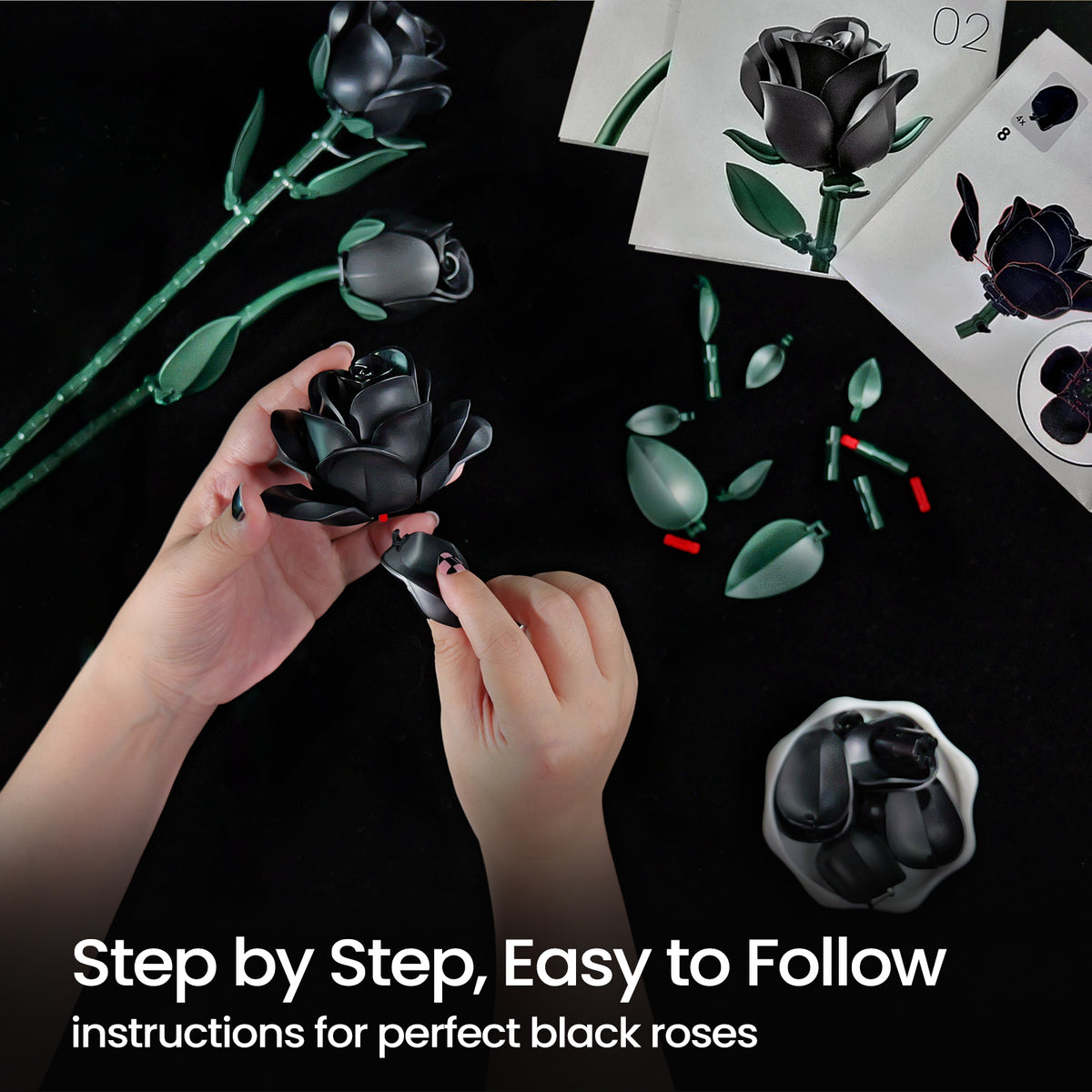 A person assembling a black rose building block set by hand, with rose components, leaves, stems, and instruction guides displayed on a dark surface, showing the step-by-step assembly process.