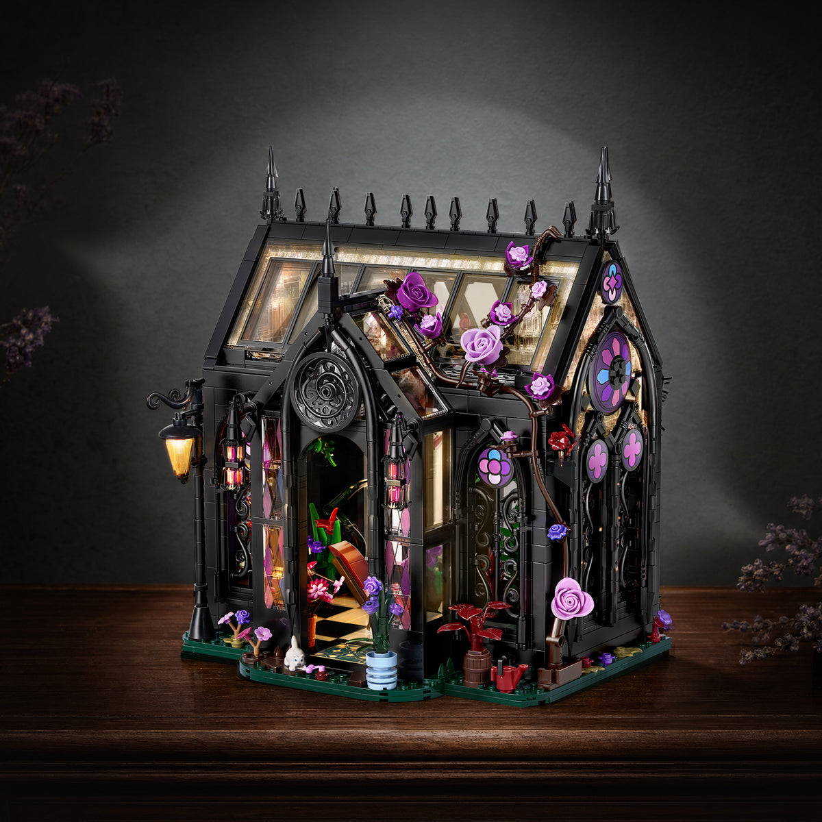 Gothic Greenhouse building block set with black architectural frames, purple flowers, stained-glass windows and a detailed botanical interior displayed on a wooden table