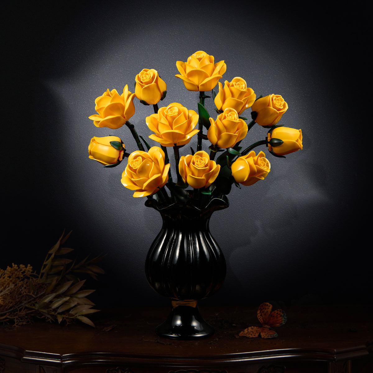 Yellow rose bouquet building set displayed in a black vase on a dark wooden table, featuring a full arrangement of bright yellow roses with green stems in an elegant interior setting.