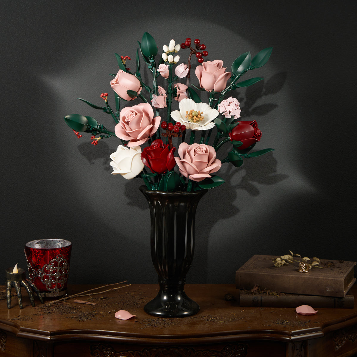 Pink rose bouquet building block set displayed in a black vase, featuring soft pink roses, white flowers, green leaves, and berry accents arranged as an elegant floral centerpiece on a dark vintage table.