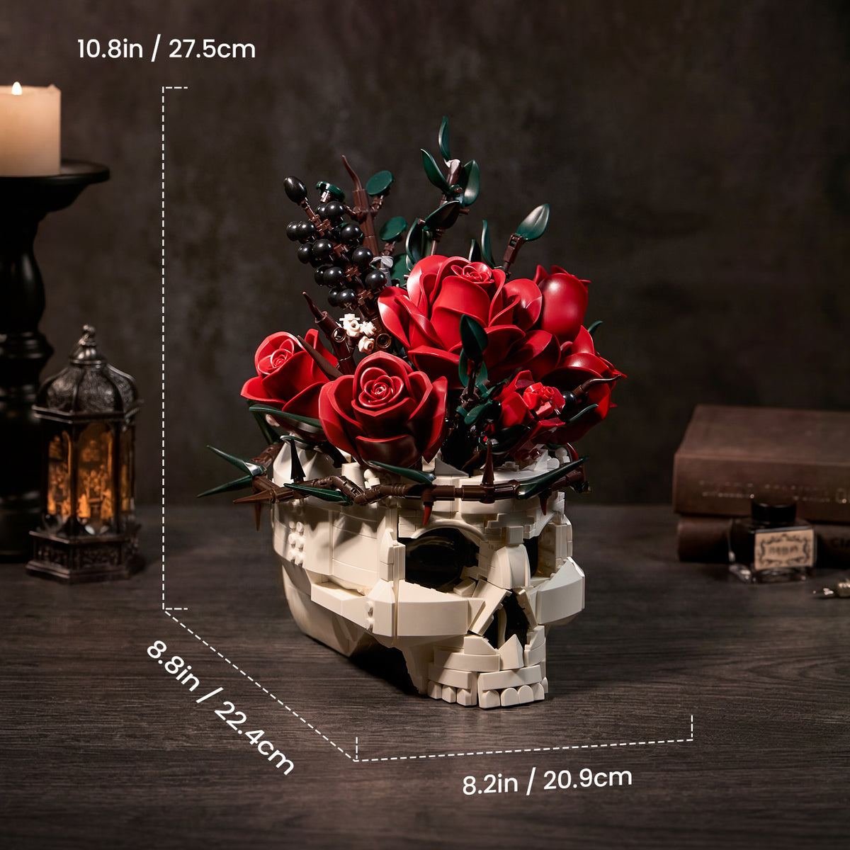 Gothic skull red rose bouquet building block set displayed on a dark tabletop, featuring a white skull base with red roses, blackberries, and botanical details, with product dimensions shown at approximately 10.8 inches tall.
